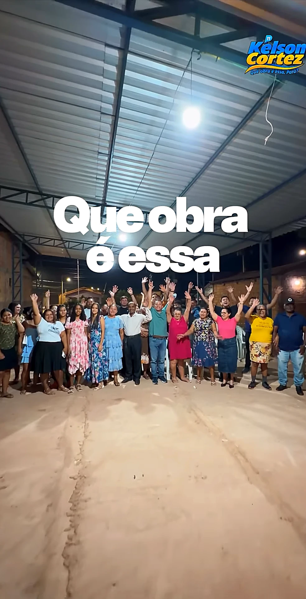 Evento noturno de campanha com moradores de braços erguidos